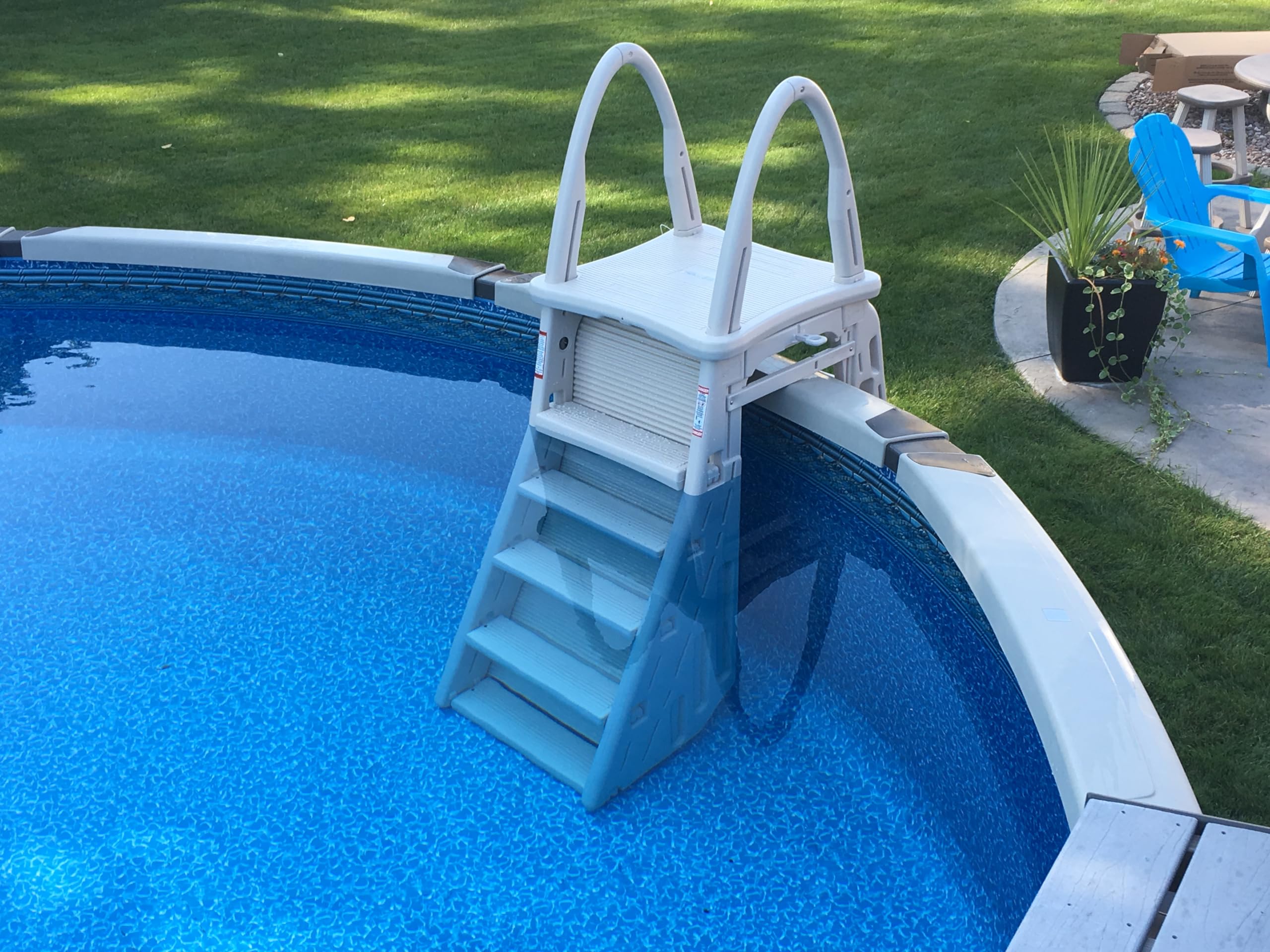 Confer Roll-Guard ladder mounted on a blue-liner round above-ground pool, top-down backyard view