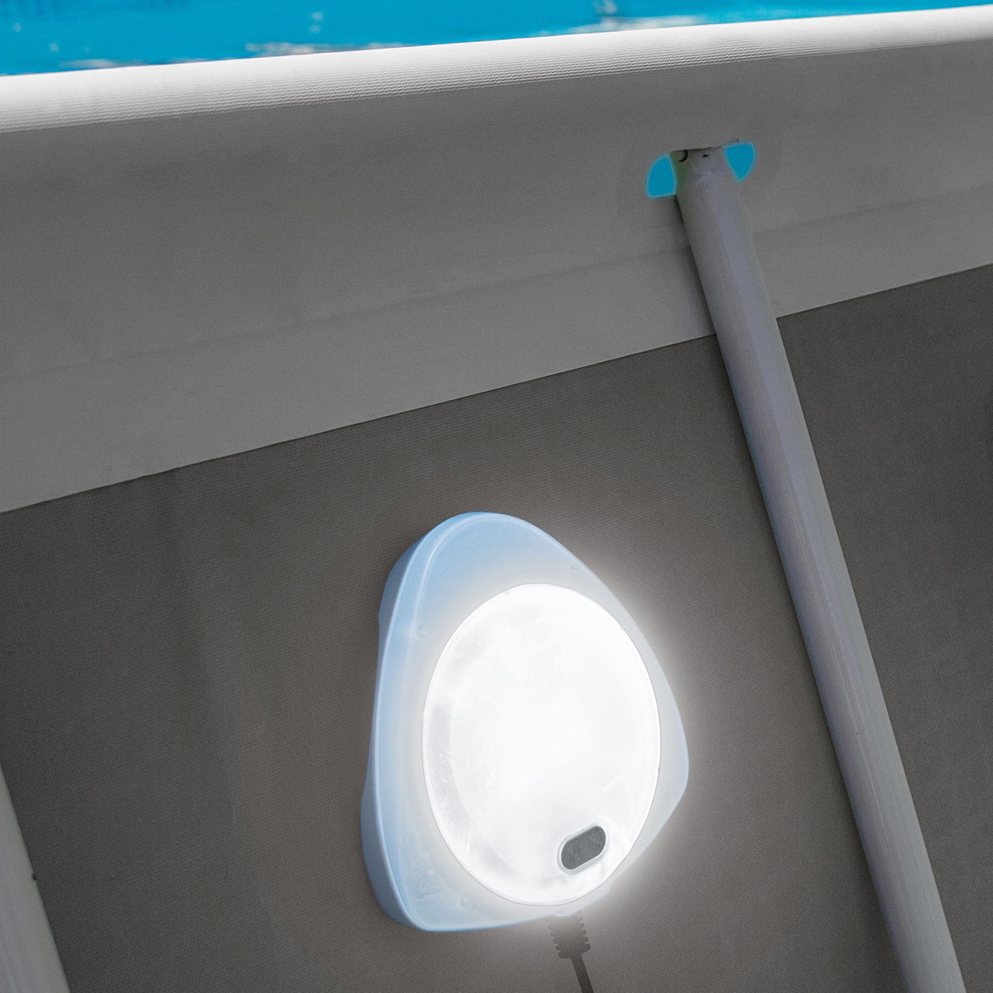 Intex LED light mounted on a pool wall and glowing white, viewed from outside the pool